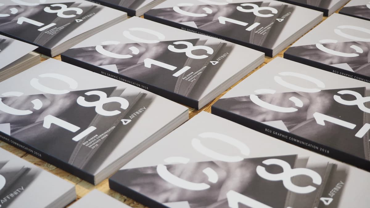 Copies of the BCU Graphic Communication 2018 graduate show catalogue laid out in a grid