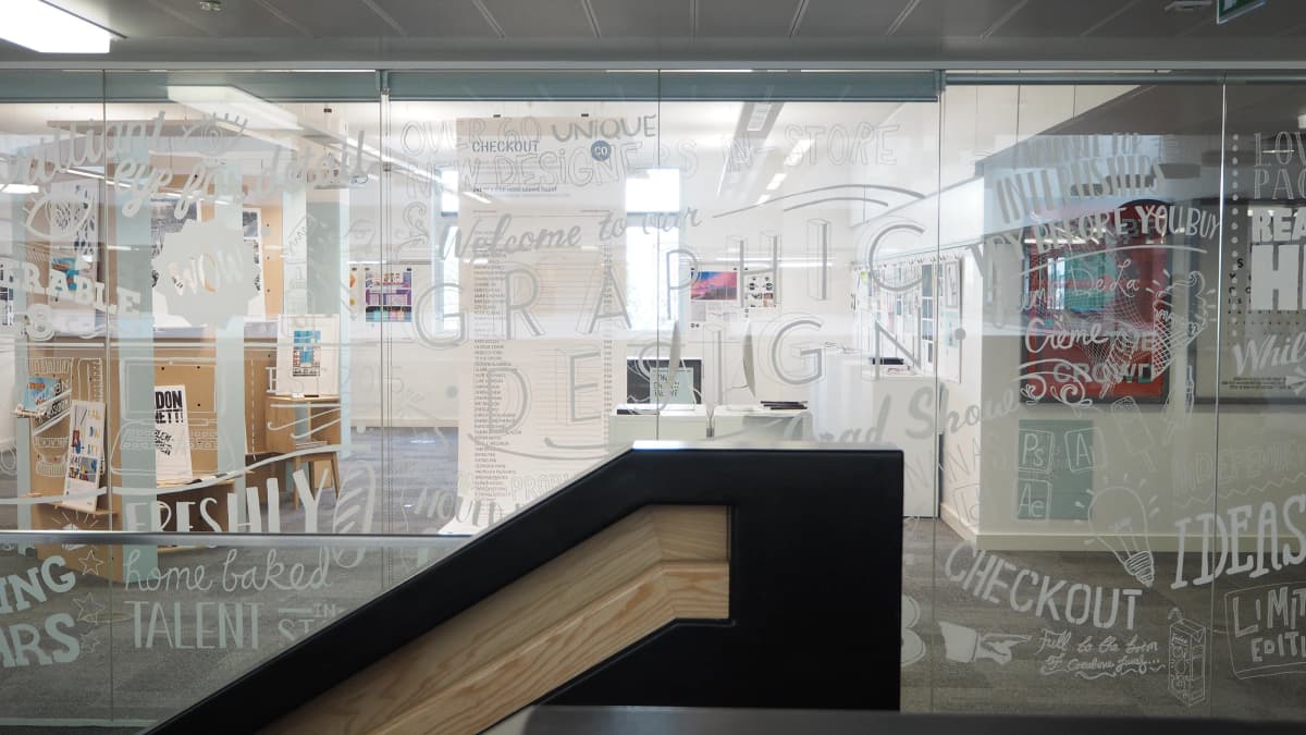 The glass wall of the BCU graduate show, hand lettered with the names of the graduating designers